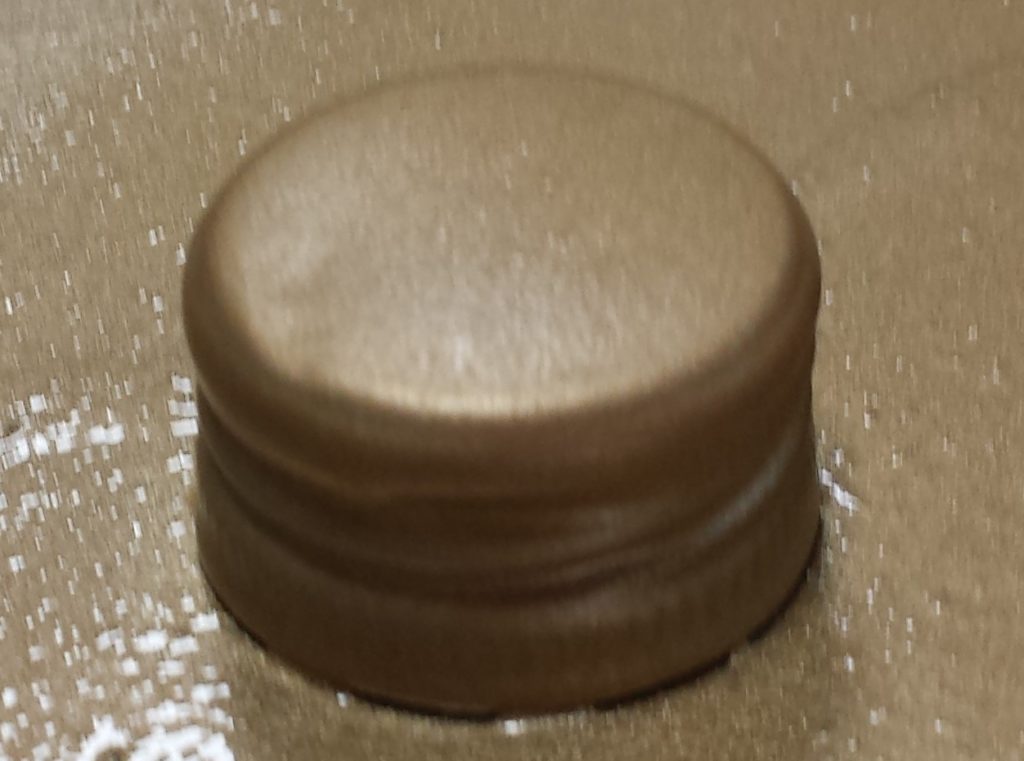 Fourth and final layer of gold spray paint on the lid of the wine bottle.