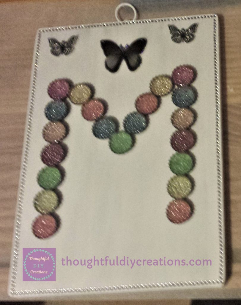 2 Silver Metal Butterflies attached to the top of the chopping board.