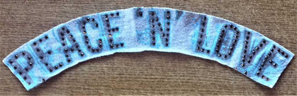 The words 'PEACE 'N' LOVE' cut out from an old jacket.