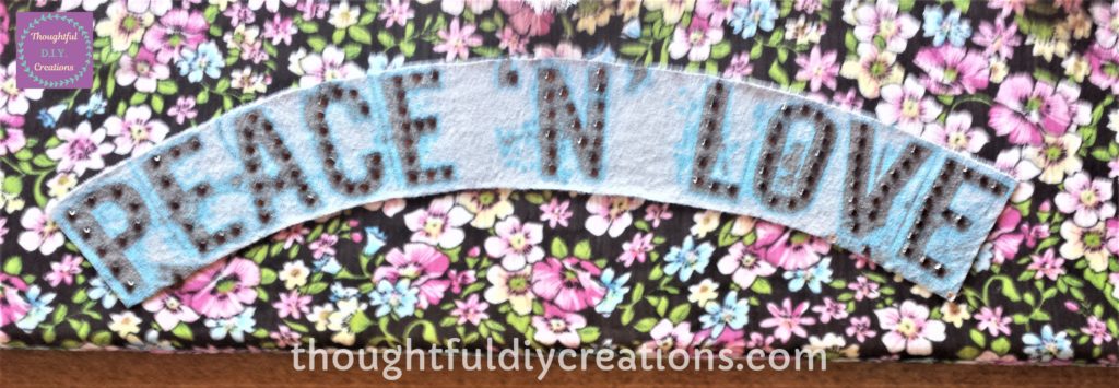 The words 'Peace 'N' Love' after being glued to the canvas.