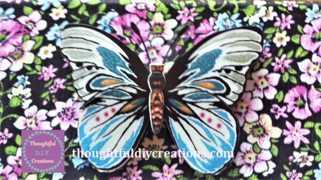 Close up image of the 5-D Butterfly Sticker on the floral fabric canvas.