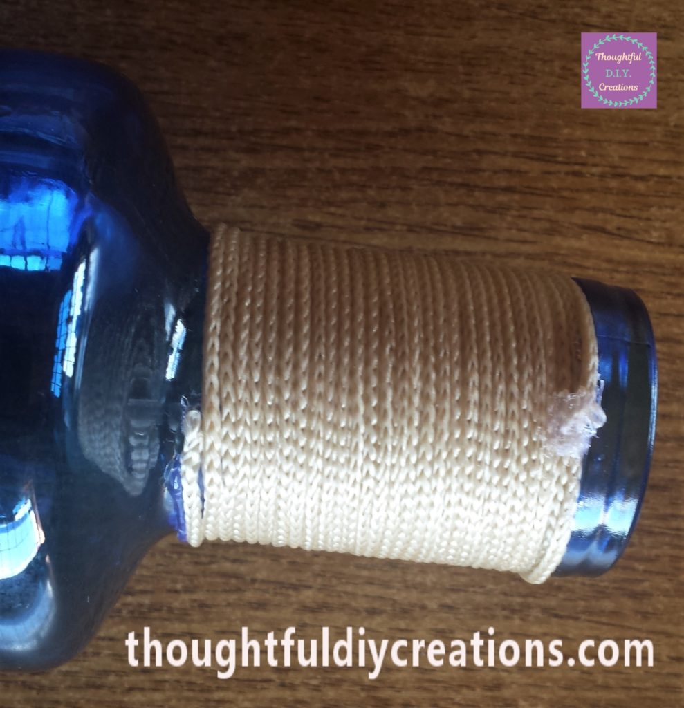 The string hot glued to the top of the neck of the bottle.