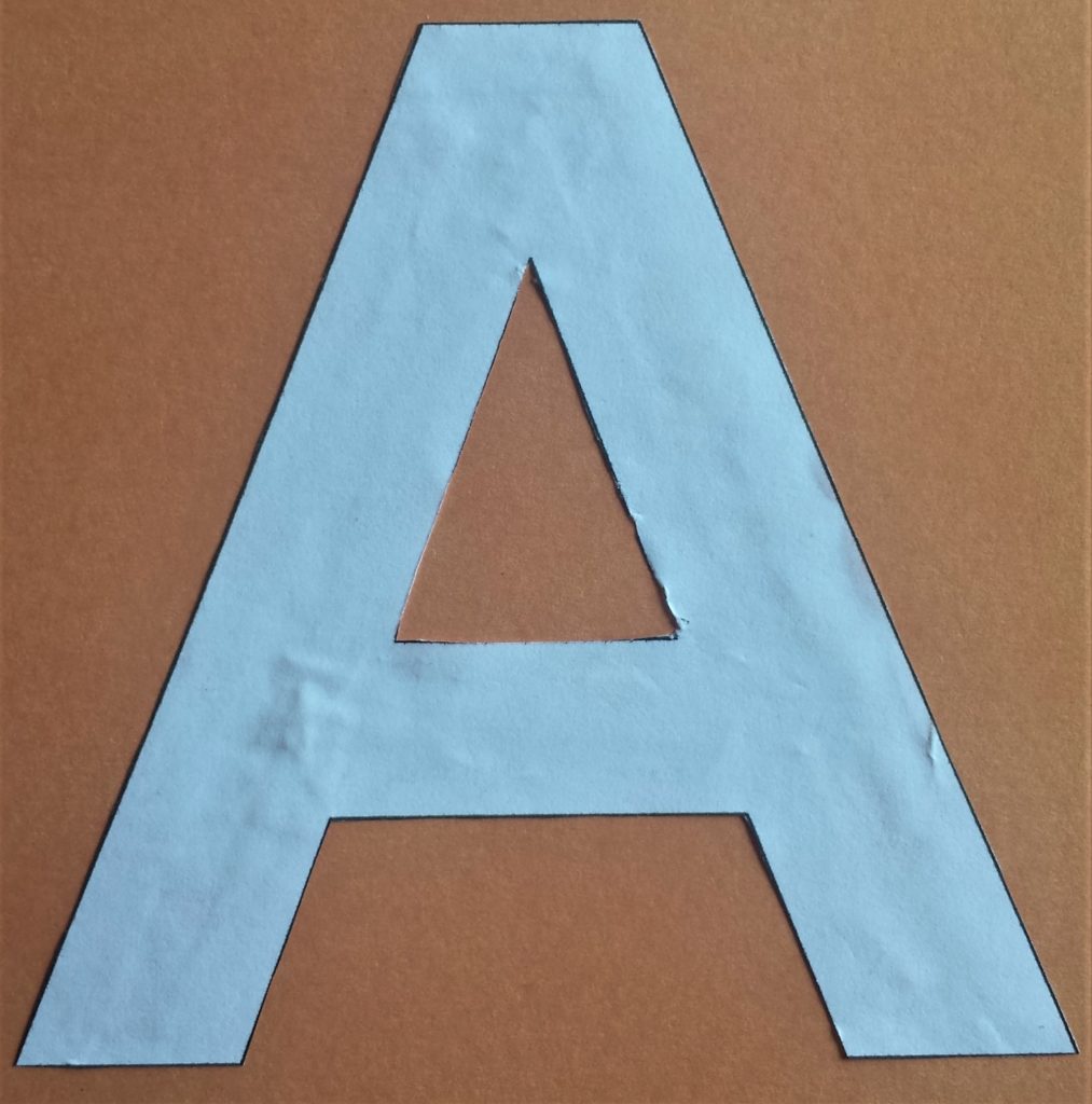 The letter 'A' glued to the autumn paper.