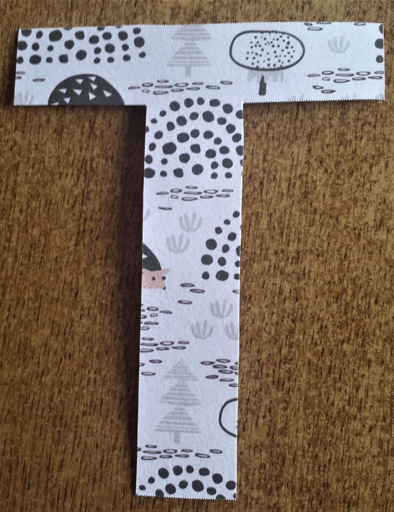 The letter 'T' covered with the Autumn paper.