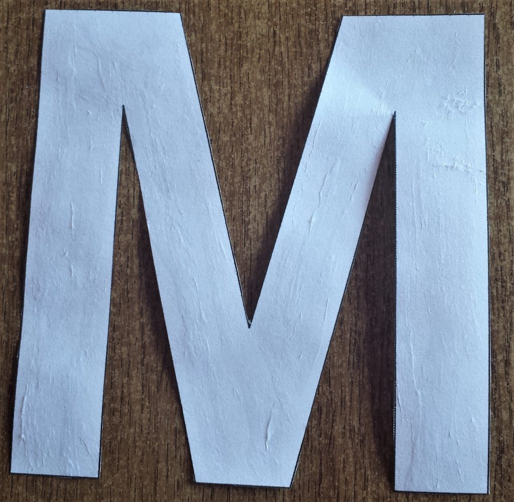 The letter 'M' with pritt stick on it.