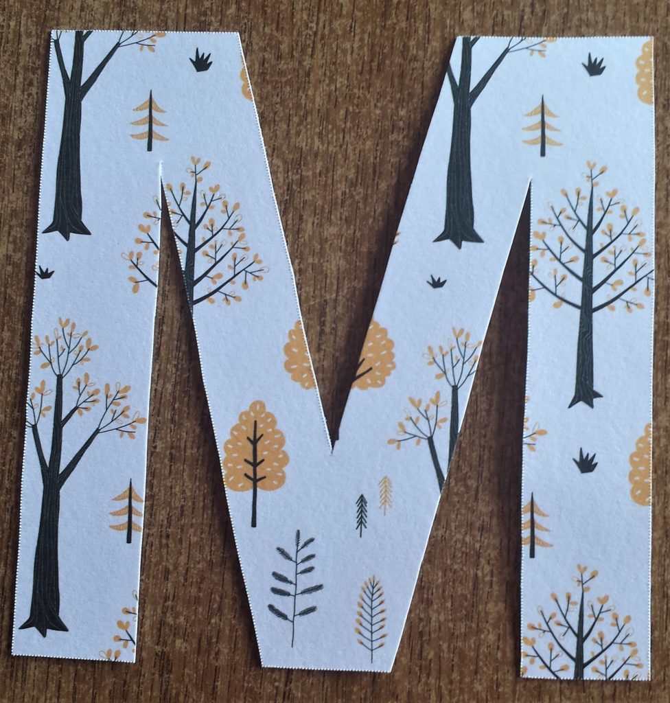 The letter 'M' cut out and covered with Autumn paper.