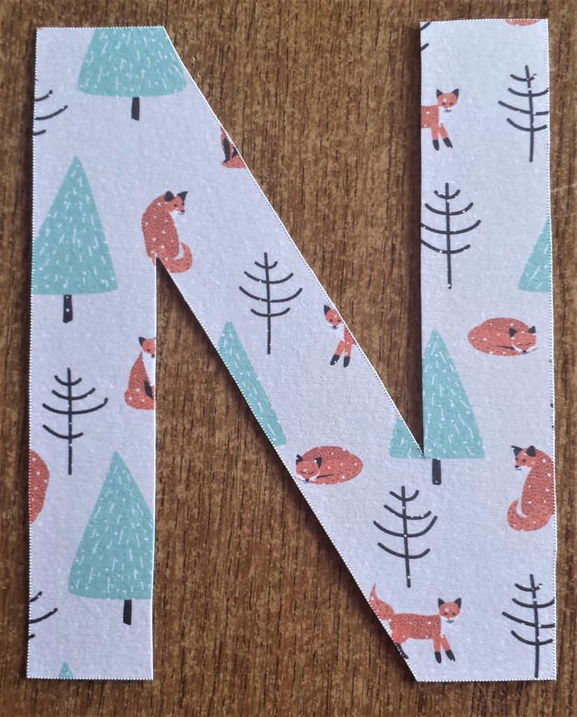 The letter 'N' cut out and covered with Autumn paper.