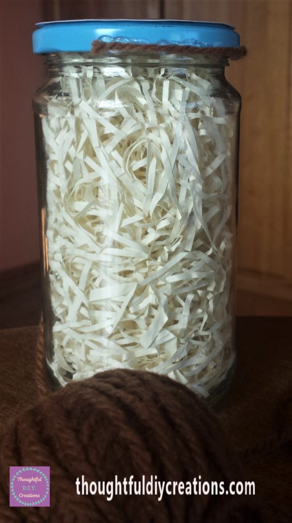 Hot glue on the bottom edge of the lid with brown wool over it.