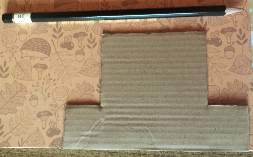Tracing around the cardboard hat onto the autumn paper.