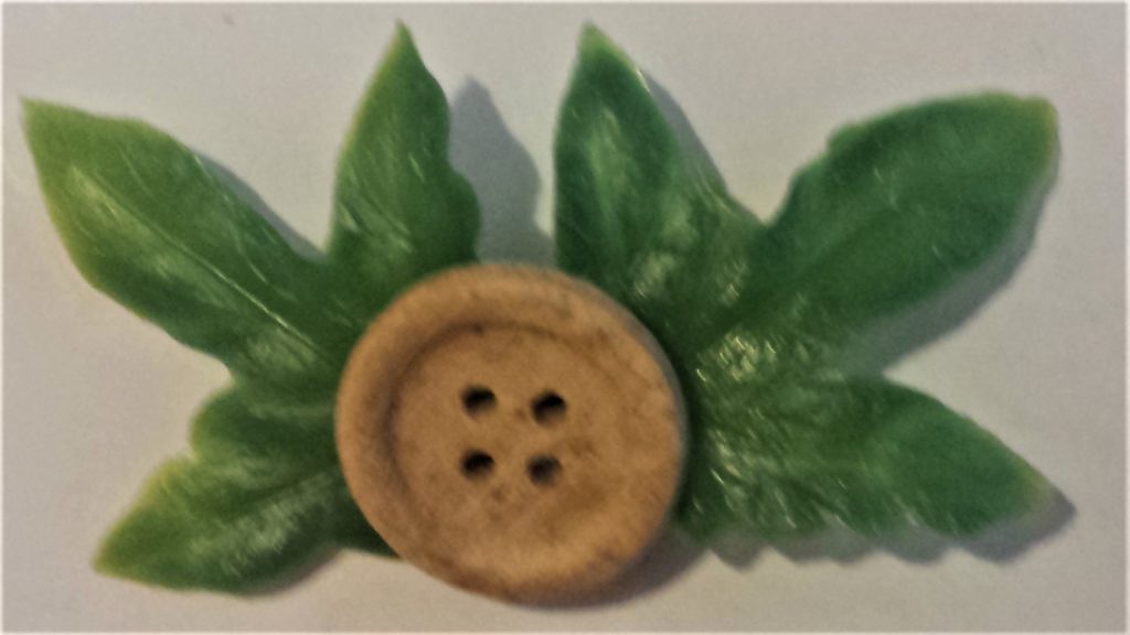 The leaves hot glued to the button.