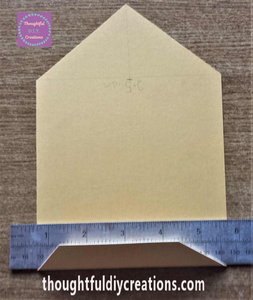 Folding the paper over the ruler to ensure it is straight.