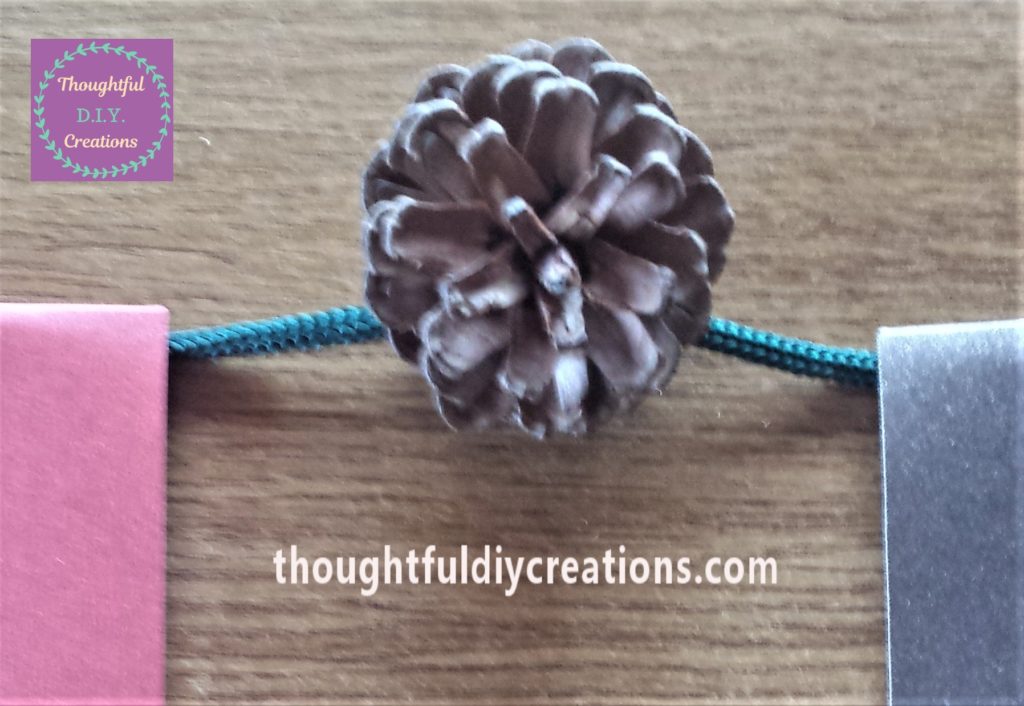 Pine cone glued to the string.