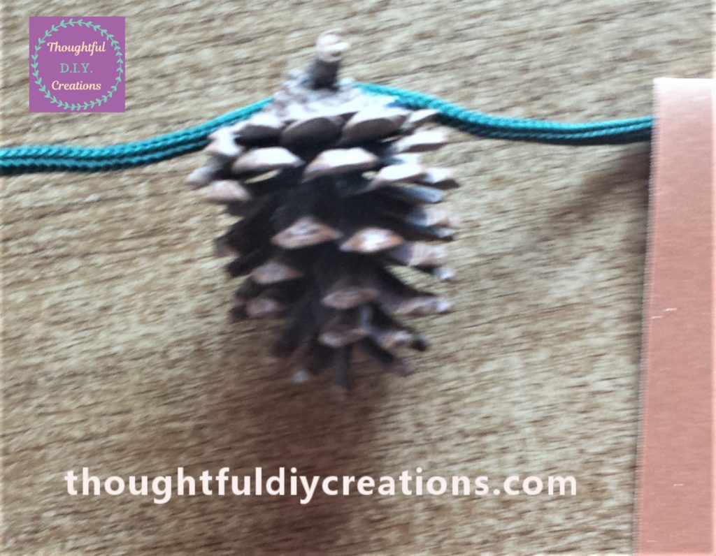 Pine cone glued to the string.