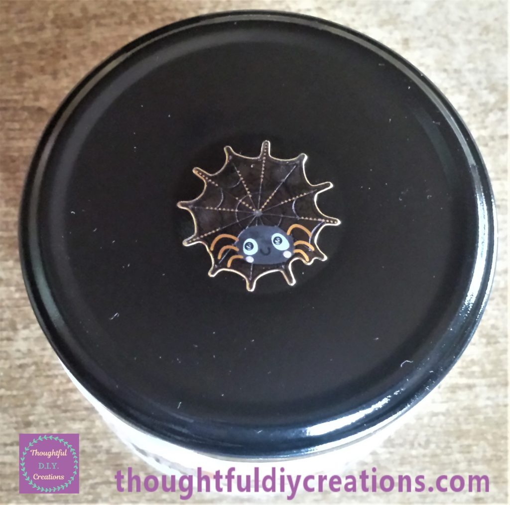 Sticker of spider and cobweb on the lid of the jar.