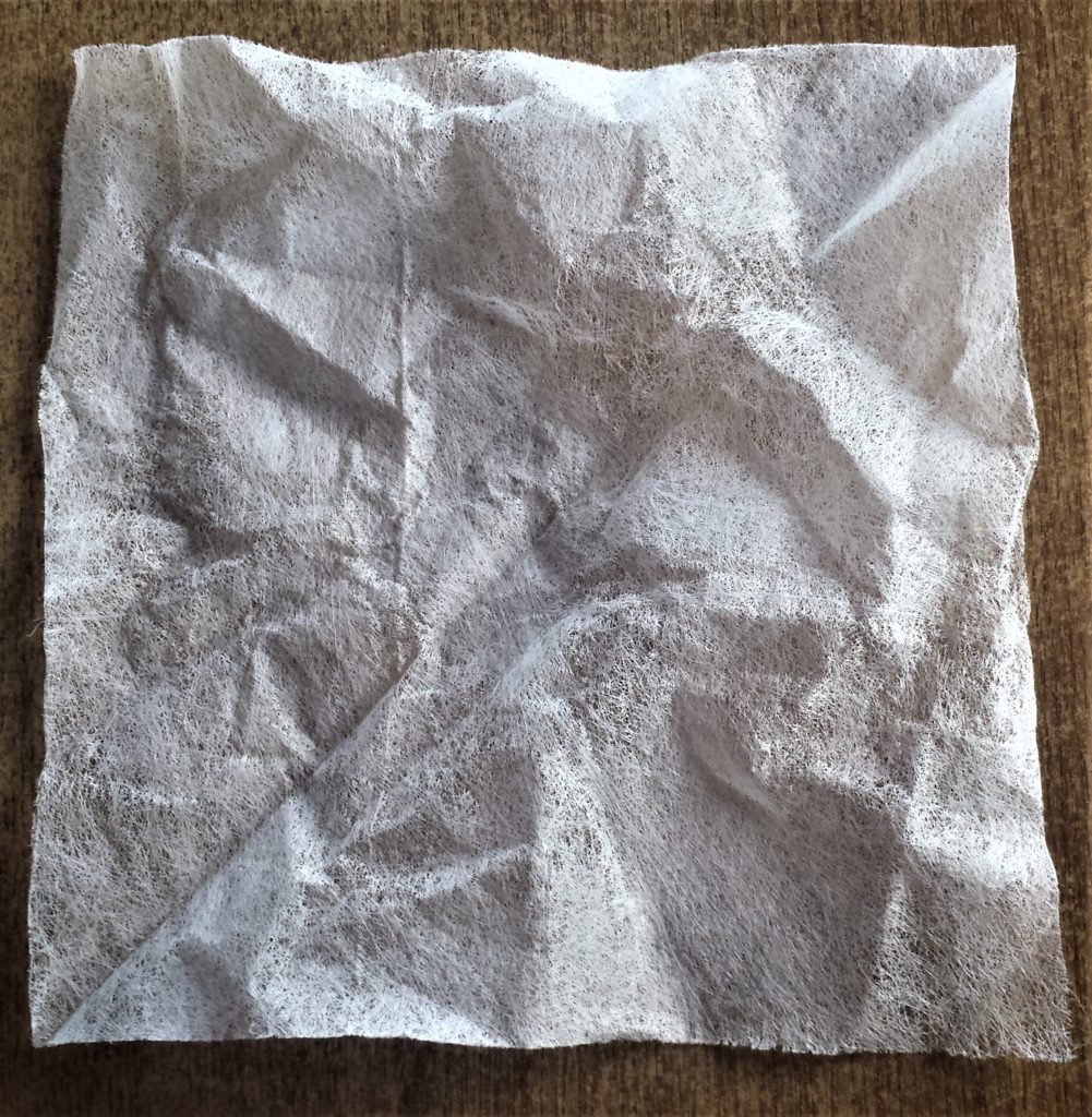 Putting one corner to the opposite corner on the tumble dryer sheet.