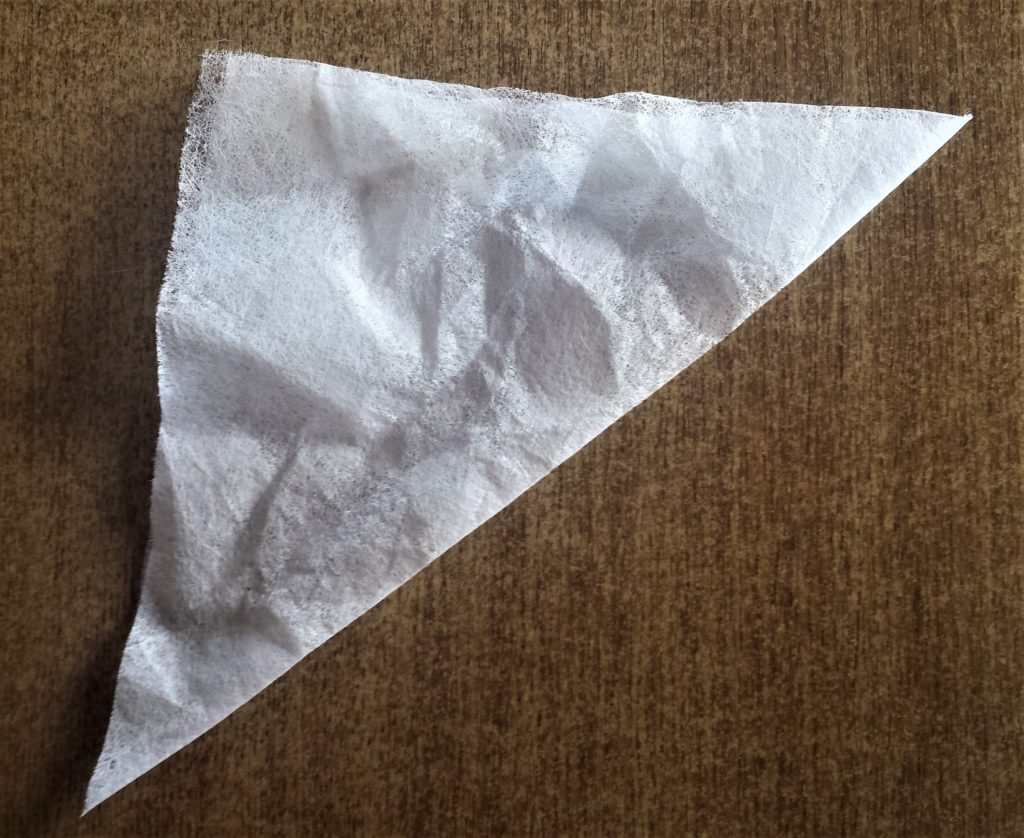 Tumble dryer sheet folded over to make a triangle shape.
