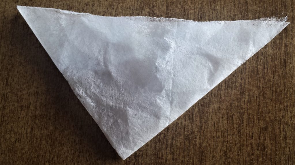 Tumble dryer sheet folded over into a smaller triangle.