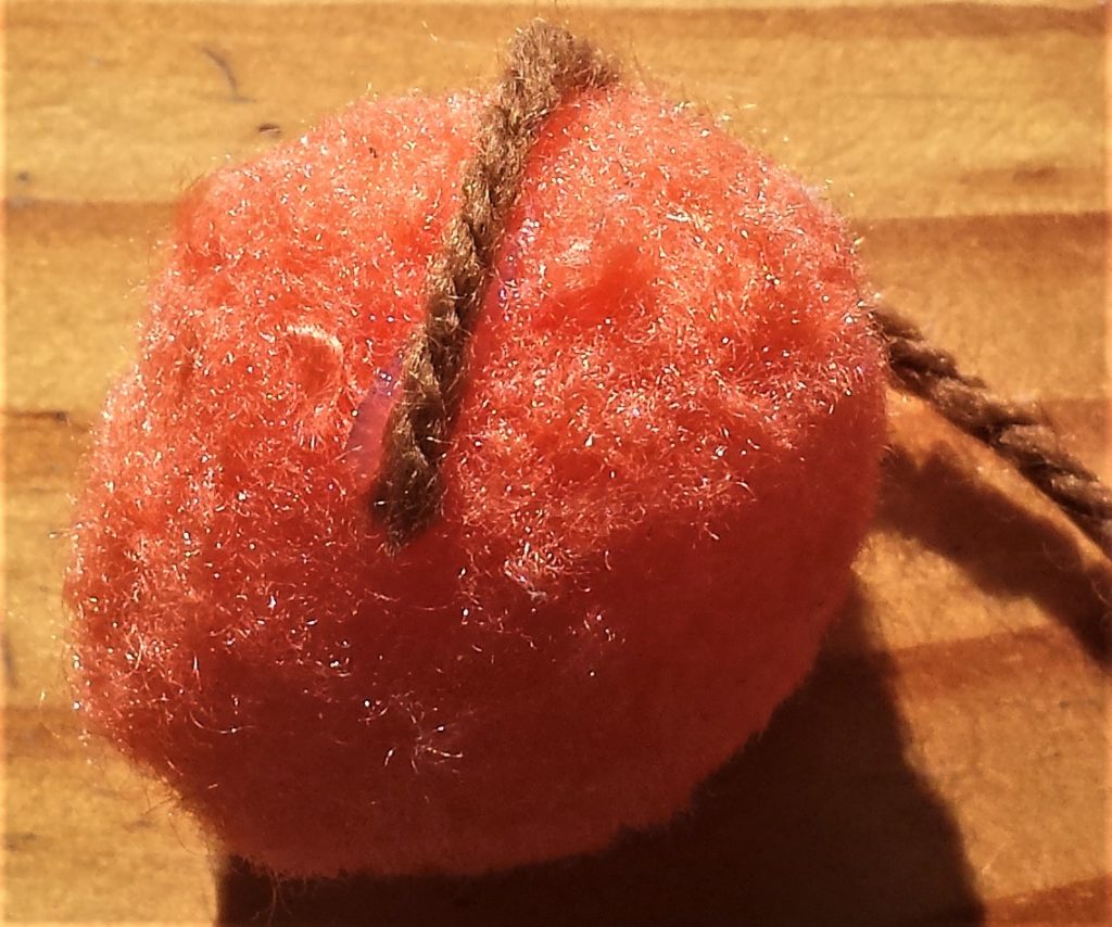 Wool over the dot of hot glue on the pom pom.