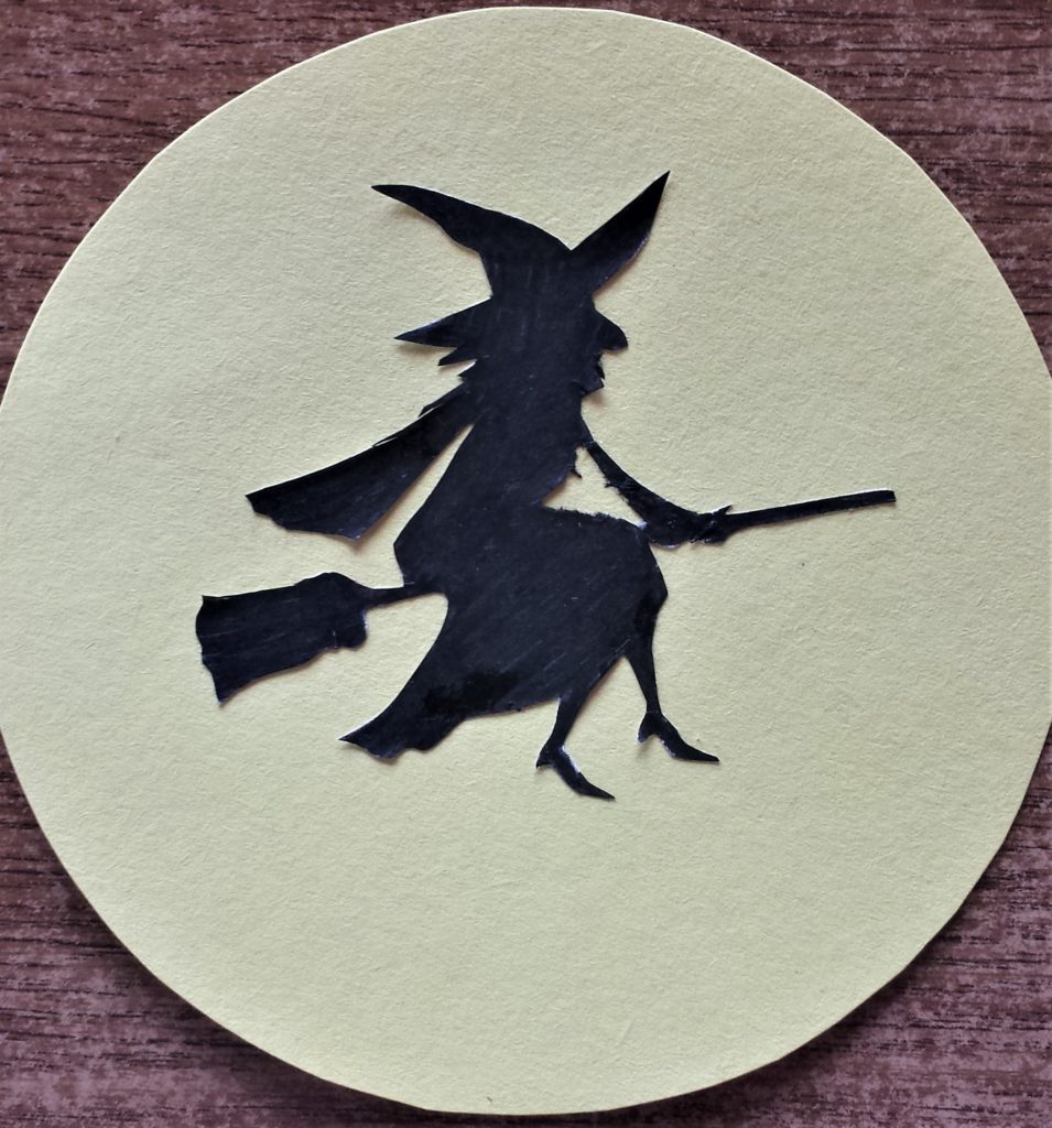 The witch silhouette attached to the moon.