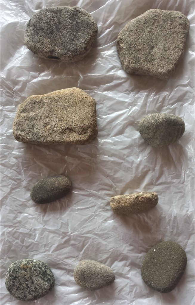 Nine stones laid out washed and dried ready to be painted.