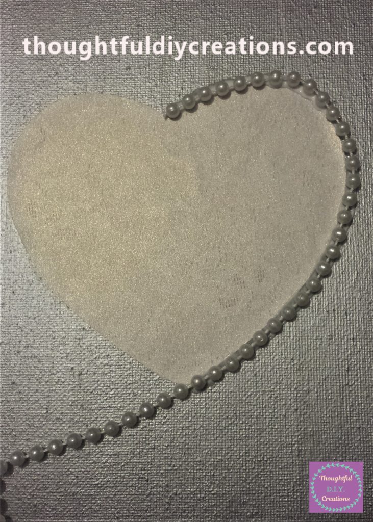 The beads glued to half of the heart on the canvas.