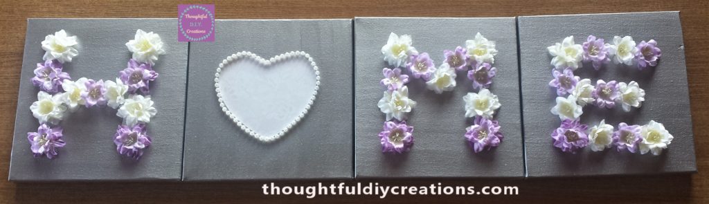 The flowers arranged on the canvases to spell the word home.