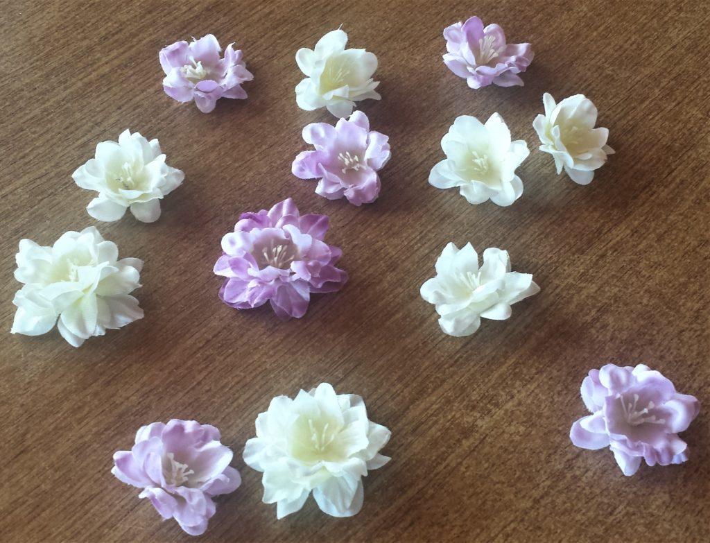 Cream and purple flowers removed from their stems.