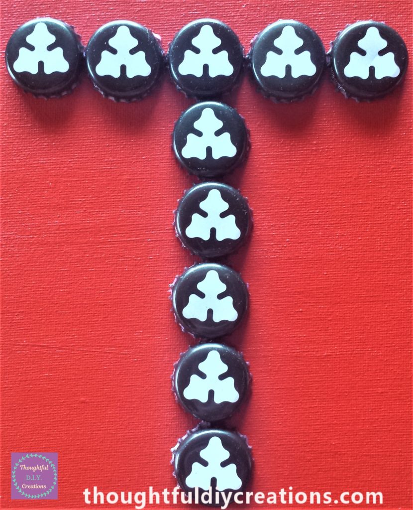 Close up of the beer bottle caps on the canvas board.