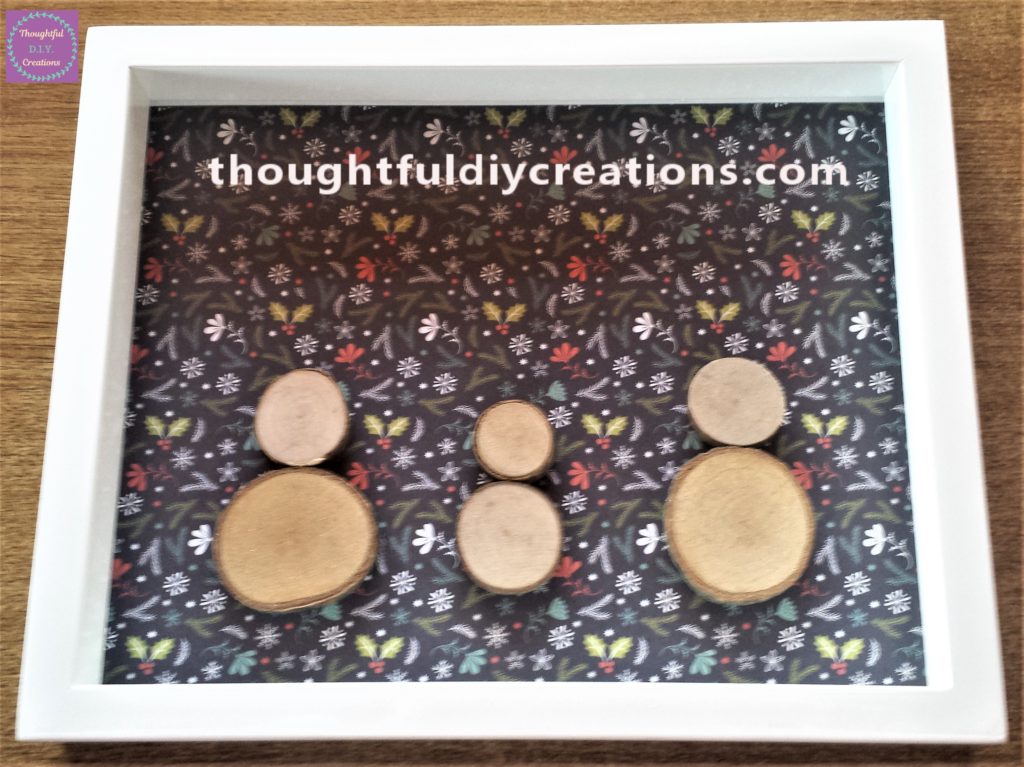 The 3 Snowmen on the Christmas paper with the frame over it.