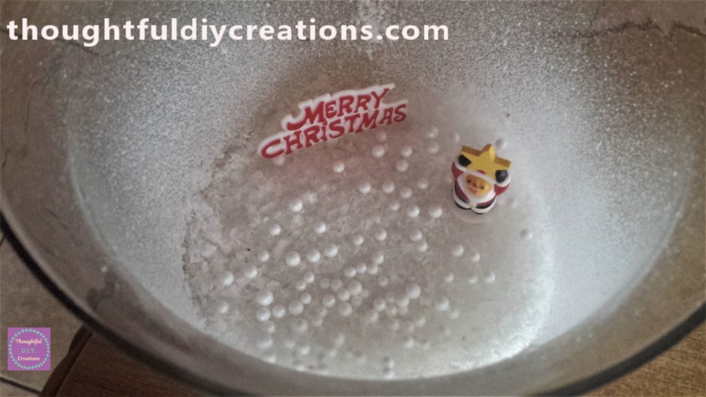 The Santa Claus figurine in the snow.