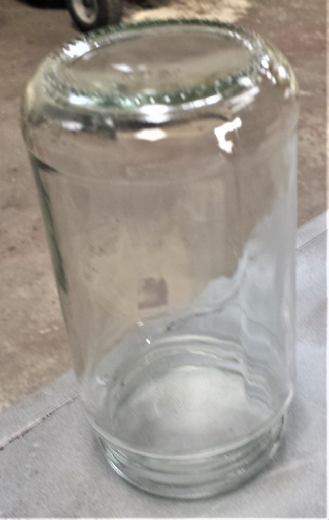 Biggest Jar upside down on the table in the shed ready for spray painting.