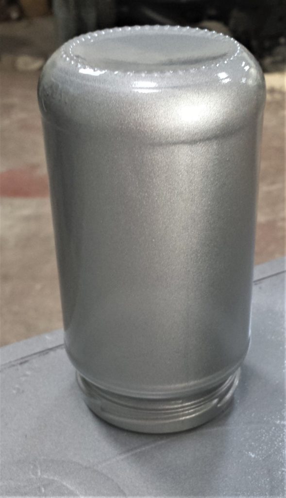 The second layer of silver spray paint on the jar.