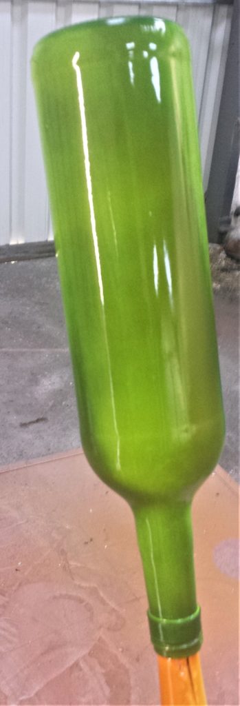 First layer of spray paint on the wine bottle.