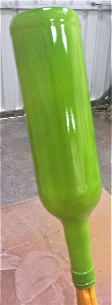 The second layer of spray paint on the bottle.