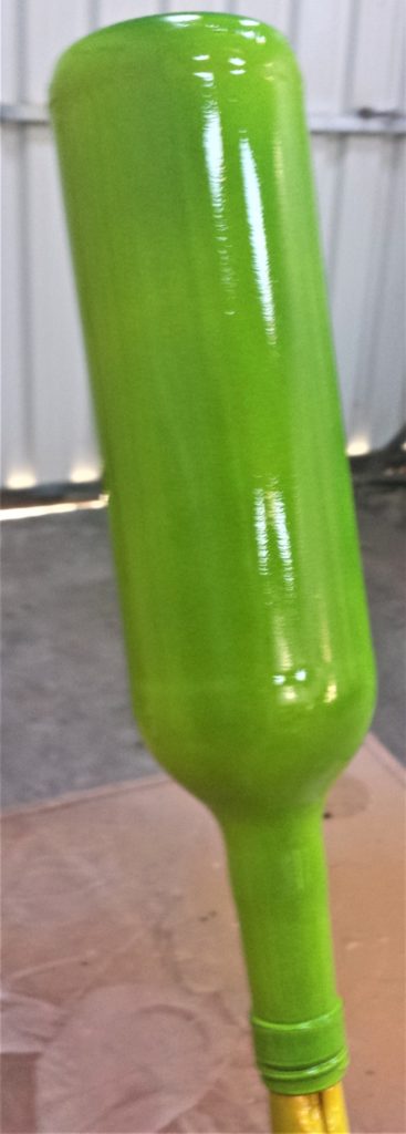 The third coat of spray paint on the bottle.