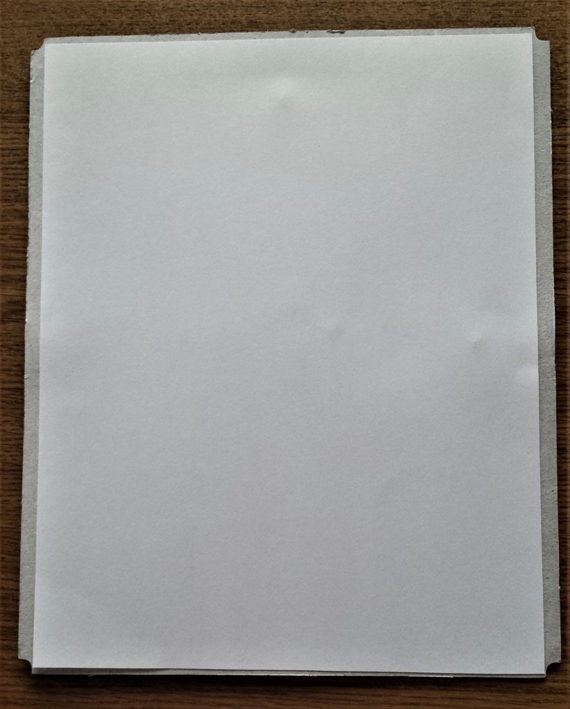 The sheet attached to the backing board of the frame.