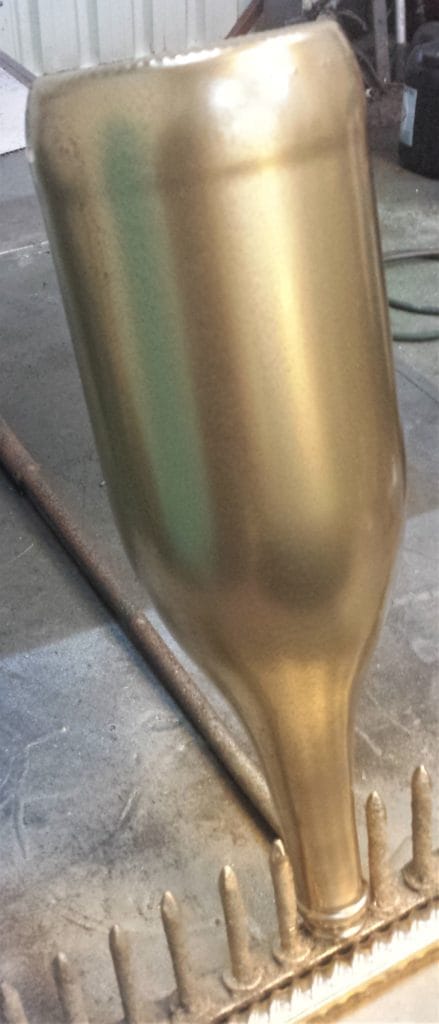 The second layer of spray paint on the bottle.