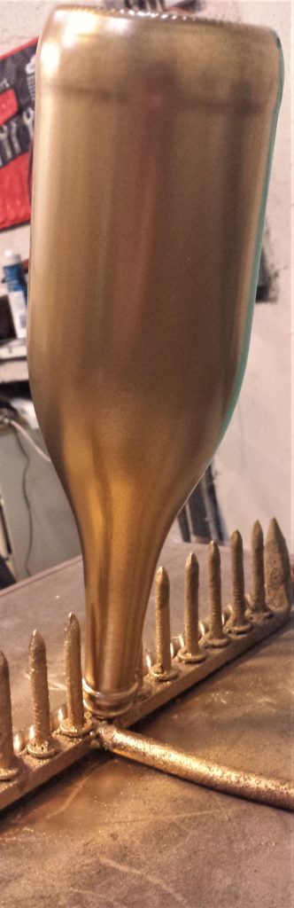 The third coat of spray paint on the bottle.