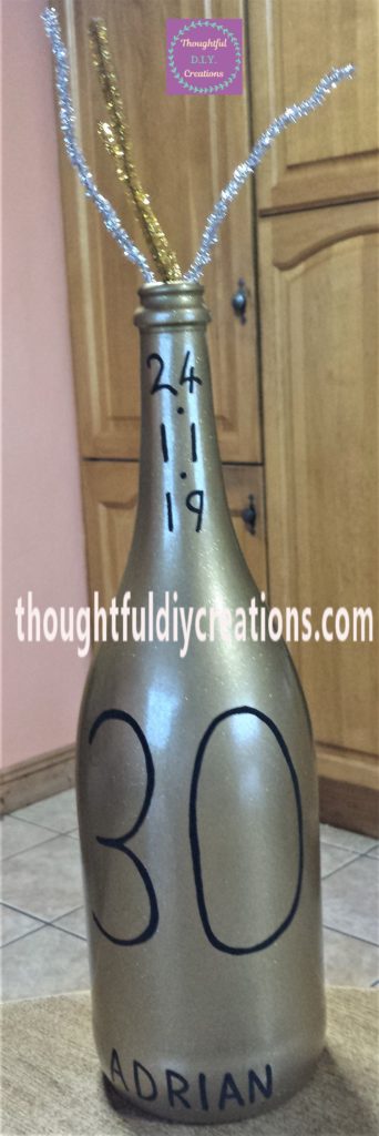 Gold glitter pipe cleaner hot glued to the inside of the bottle.