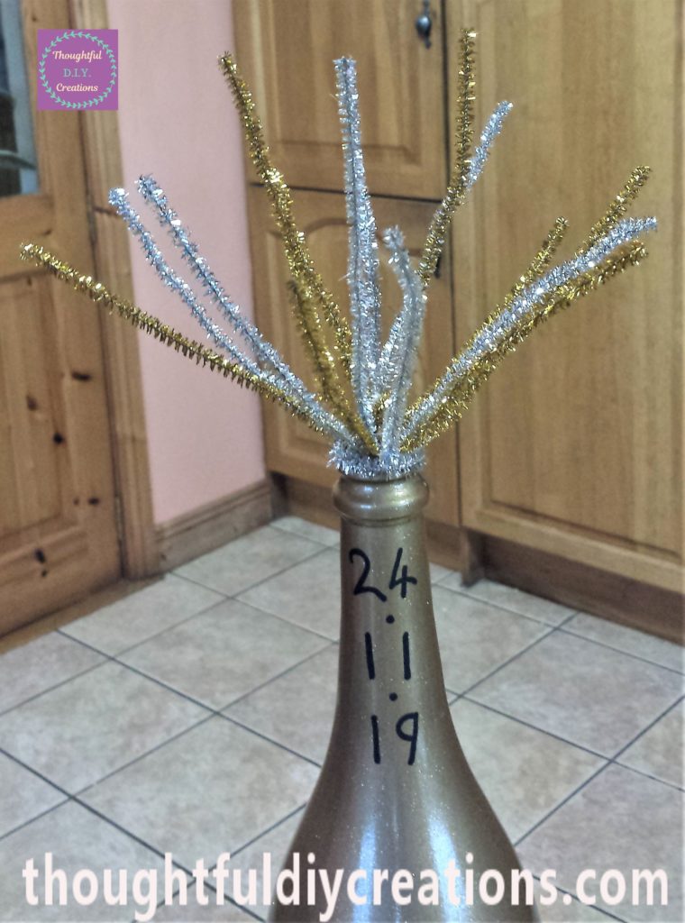 Silver pipe cleaner hot glued to the top of the bottle.