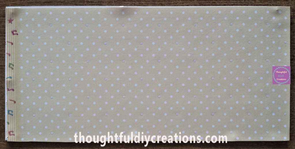 Polka dot page attached to the backing board of the frame.