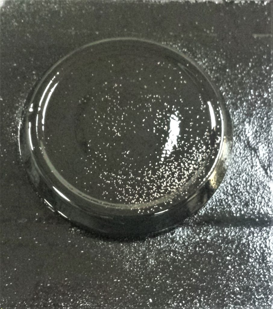 Lid of the jar spray painted with black spray paint.