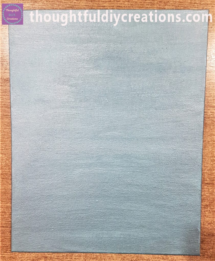 The teal paint on the canvas board.