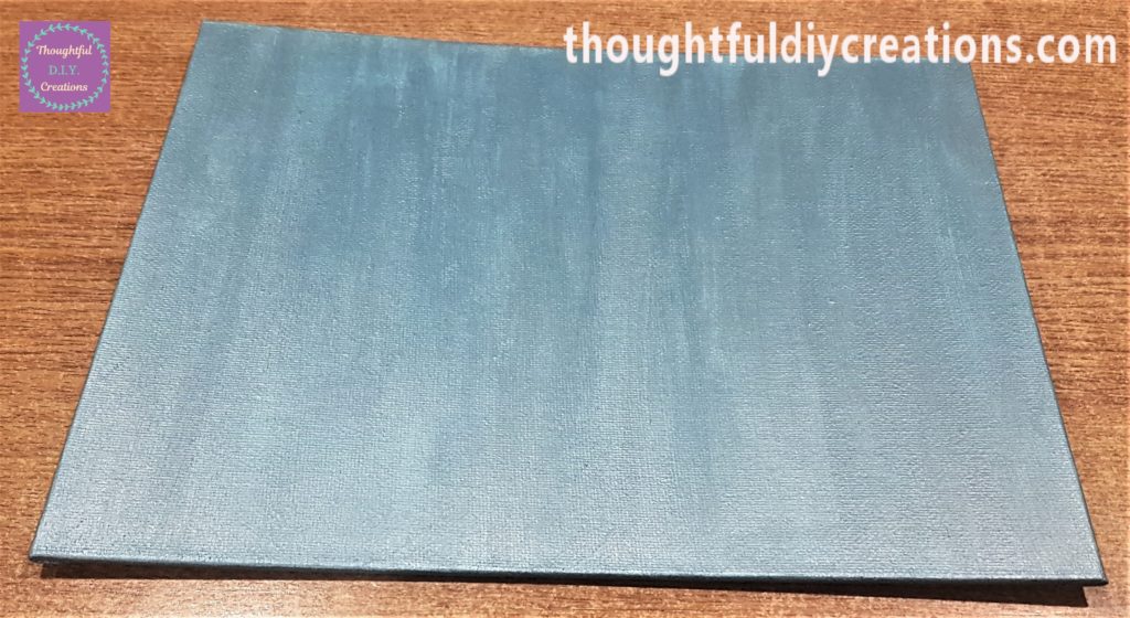 Another angle of the canvas board with teal paint.