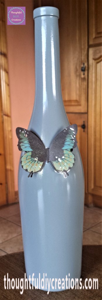 Green and Black Butterfly attached to the bottle.