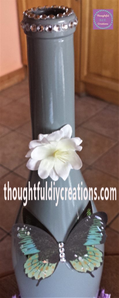 Close up image of the clear self-adhesive gemstones on the bottle.