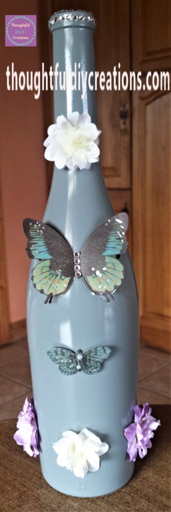 A smaller green and black butterfly sticker with pearls in the mid-section, added to the bottle.