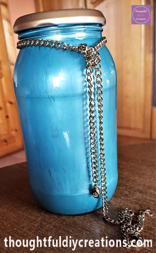 Back of the jar with the gold chain tied in a knot.