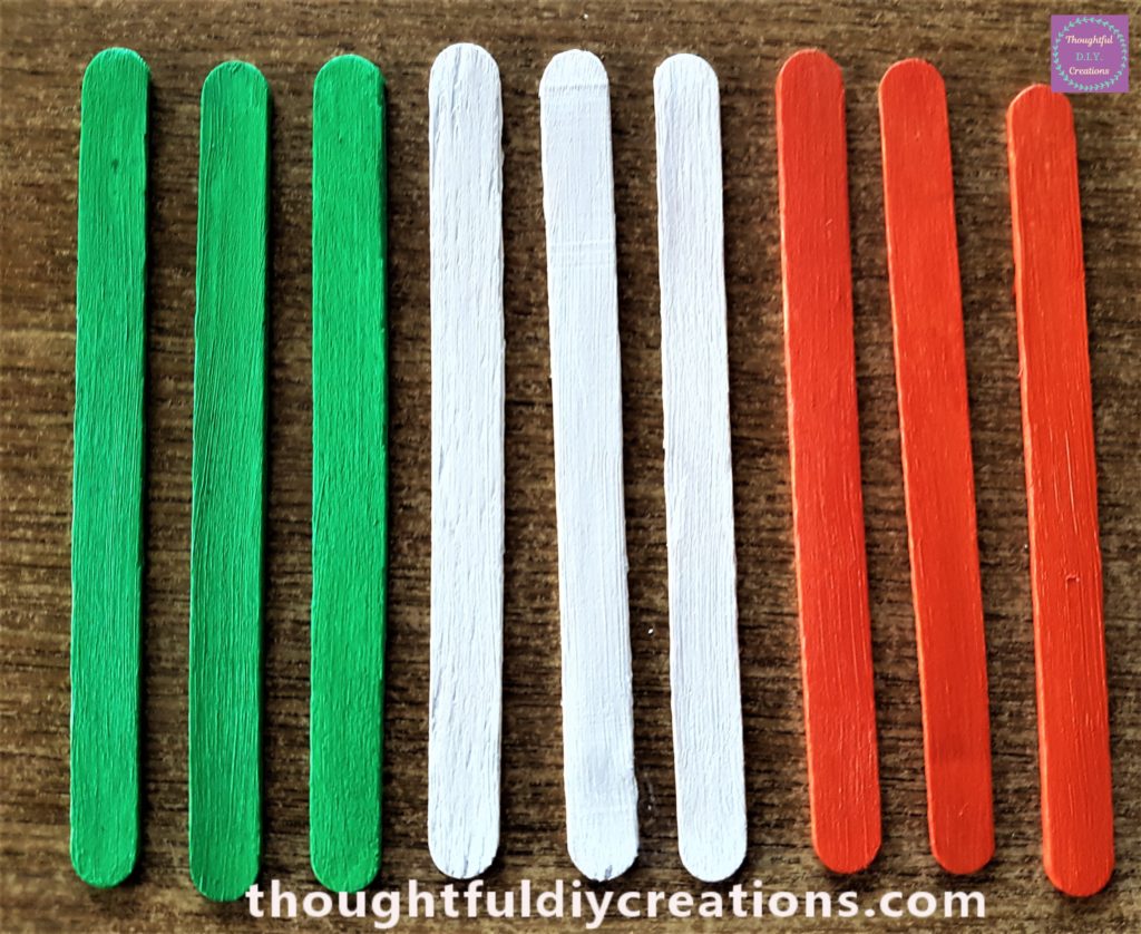 A close-up image of the lollipop sticks after the first layer of paint.