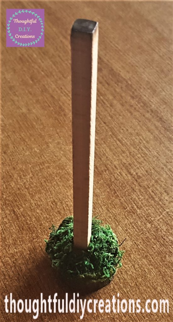 Dried moss hot glued to the wood slice to cover up the glue and add interest.